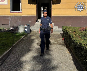 Policjantka przed budynkiem.
