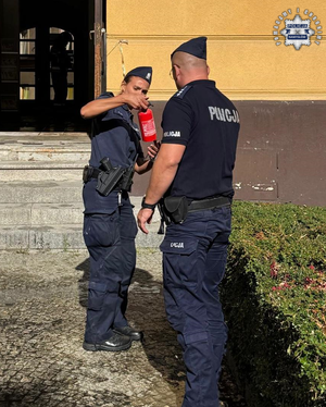 Policjantka trzyma gaśnicę, obok policjant.