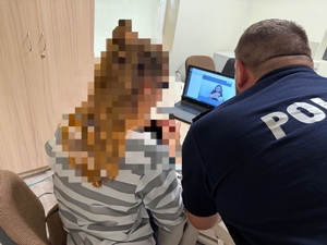 kobieta siedzi przed komputerem na którym jest policjantka tłumacz.