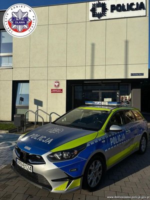 Radiowóz stoi przed budynkiem jednostki Policji.