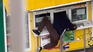 Mężczyzna włamujący się do kiosku.