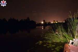 Zbiornik wodny. Na brzegu zarośla.