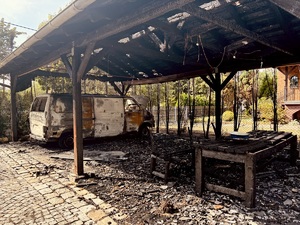 Wiata uszkodzona w pożarze, pod nią stoi bus.