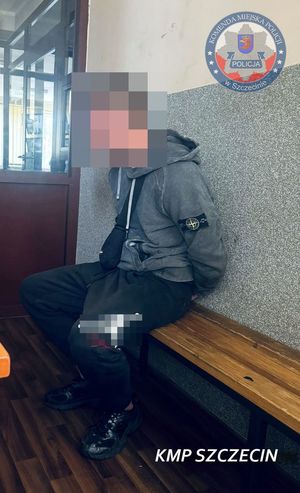 Zatrzymany mężczyzna siedzi na ławce w poczekalni.