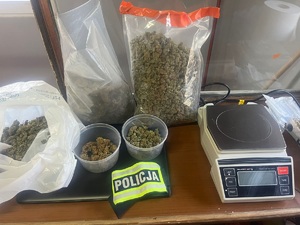 Marihuana w woreczkach i pudełkach plastikowych oraz waga elektroniczna.