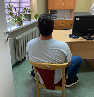 zatrzymany siedzi na krześle.