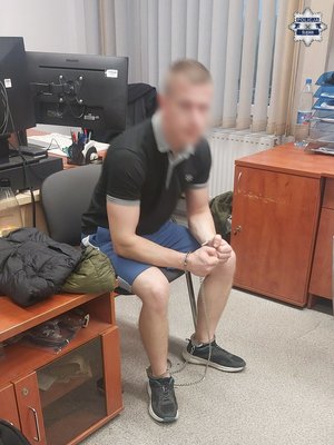 Zatrzymany mężczyzna siedzi na krześle w pomieszczeniu.
