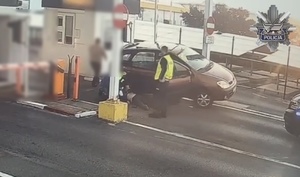 Stopklatka z nagrania monitorinfu. Policjanci udzielają pierwszej pomocy poszkodowanemu w zdarzeniu drogowym.