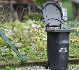Kosz na śmieci, do którego oszustka wyrzuciła skradzione pieniądze.