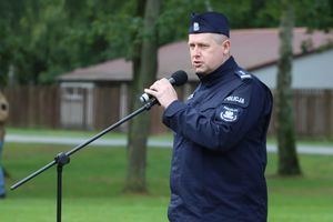 Policjant przemawia przez mikrofon.