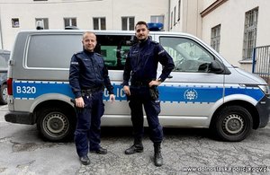 Dwaj policjanci przy radiowozie.