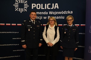 nadinsp. Tomasz Olczyk Komendant Wojewódzki Policji w Poznaniu i prof. Bogumiła Kaniewska Rektor Uniwersytetu im. Adama Mickiewicza oraz policjantka pozują do zdjęcia grupowego.