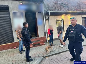 policjanci stoją przed zadymionym budynkiem.