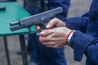 Policjantka przeładowyje broń pistolet.