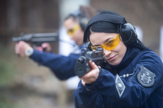 Policjanka na strzelnicy celuje z broni długiej.