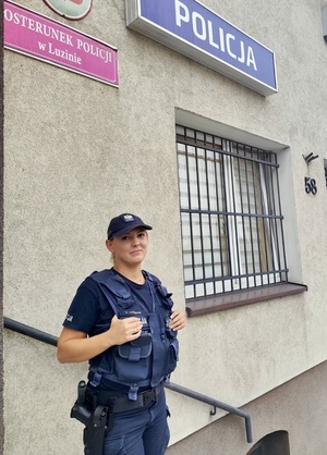 policjantka stoi przed ścianą.