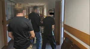 Policjanci prowadzą zatrzymanego.