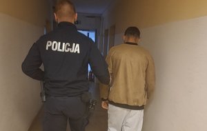 policjant idzie z zatrzymanym.