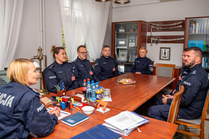 policjanci siedzą przy stole.