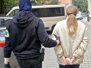 Policjant prowadzi zatrzymaną.