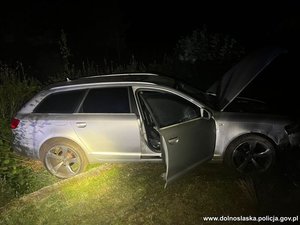 samochód stoi na zniszczonym płocie.