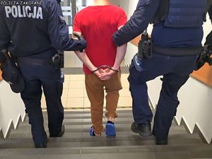 Policjanci prowadzą zatrzymanego.