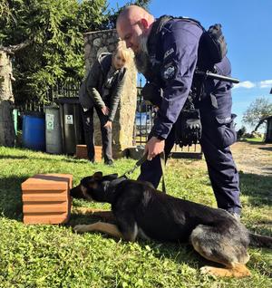 Policjant z psem podczas szkolenia.
