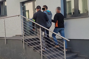 Policjanci prowadzą zatrzymanego.