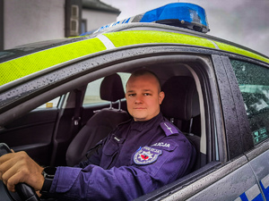policjant siedzi w radiowozie.