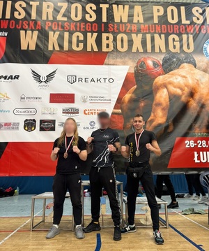 policjant sierż. Mateusz Towarnicki z dwoma innymi zawodnikami prezentuje medal.
