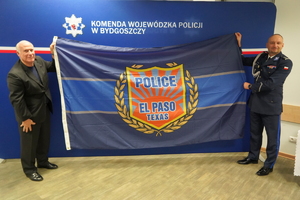 Komendant Wojewódzki Policji w Bydgoszczy razem z przedstawicielem amerykańskiej delegacji trzyma banner z logiem policji El Paso w Teksasie.