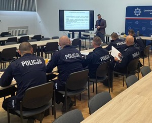 Uczestnicy kursu specjalistycznego dla policjantów, na sali siedzą w ławkach.