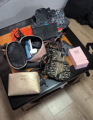 Otwarta walizka. W walizce przedmioty. Torebki, kosmetyki.