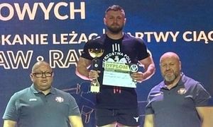 policjant stoi na podium. obok stoi dwóch mężczyzn.