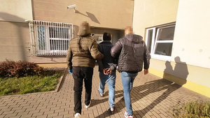 Policjanci prowadzą zatrzymanego.