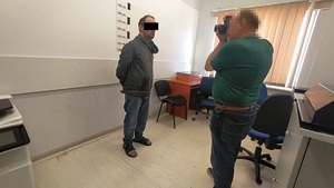 technik wykonuje zdjęcia zatrzymanemu.