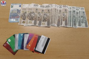 Banknoty i karty bankomatowe na stole.
