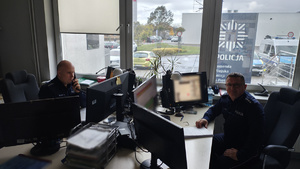 policjanci siedzą przy biurku.