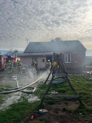 Strażacy gaszący budynek.