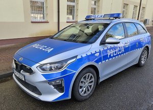 Radiowóz stoi przed budynkiem.