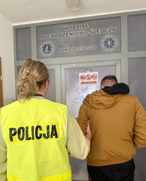 Policjantka z zatrzymanym w kajdankach.