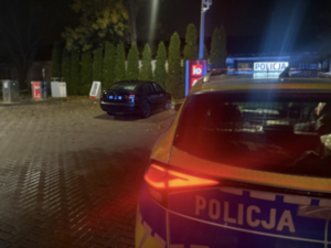 Na parkingu radiowóz i samochód osobowy.