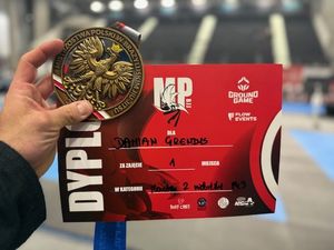 W dłoni dyplom i medal.