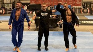 Dwaj zawodnicy, którzy stoczyli walkę i między nimi sędzia.