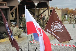 Trzy flagi. W środku flaga Polski.