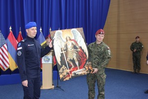 Funkcjonariusz Policji i żołnierz trzymają obraz.