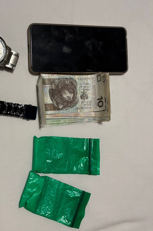 Telefon komórkowy, plik banknotów i dwa woreczki z amfetaminą.