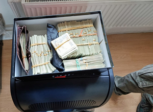 Zabezpieczone przez policjantów pieniądze w kartonowym pudełku.