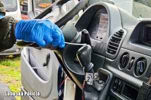 Dłoń w rkawiczce z pałeczką na gałce biegów.