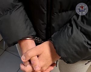 Widoczne dłonie w kajdankach.